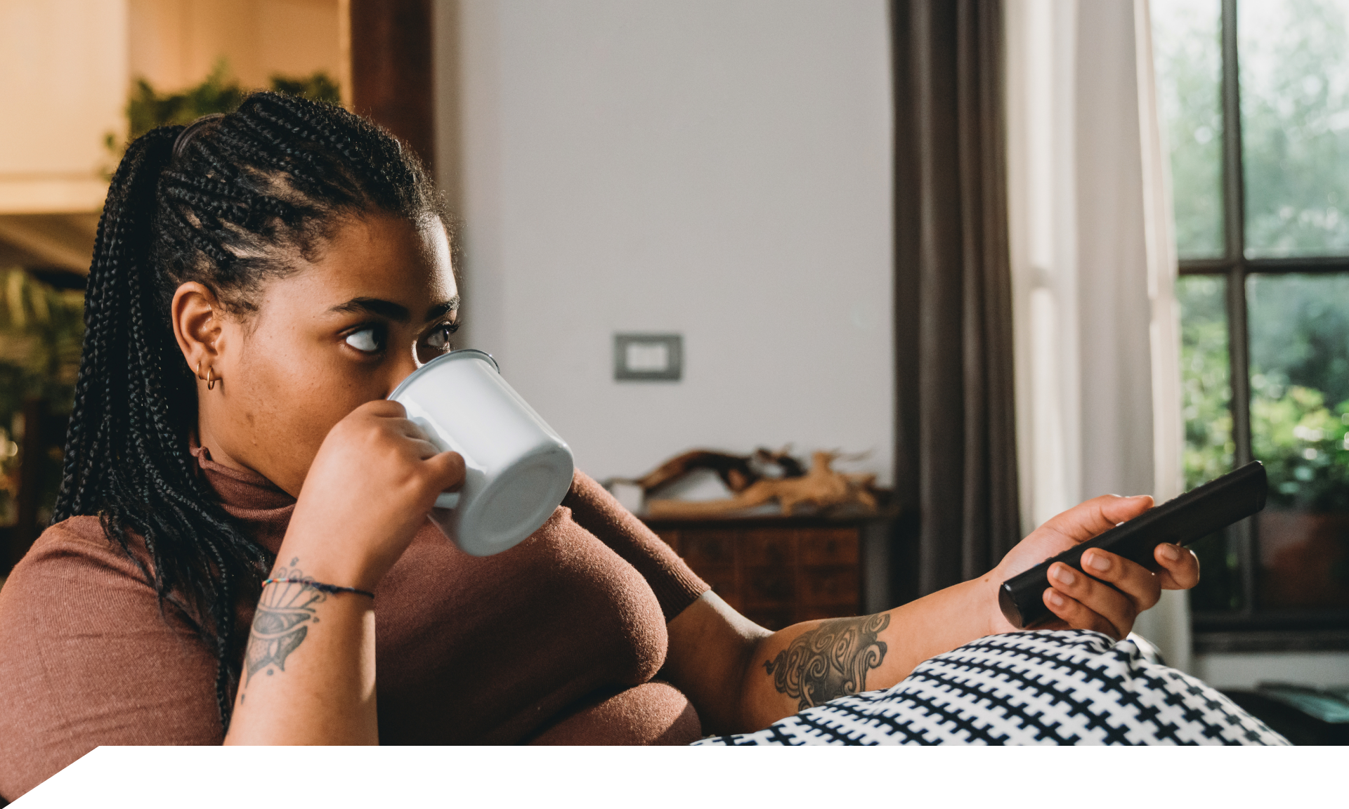 A woman laying on her couch watching TV